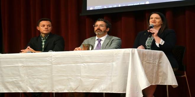 Panel discussion on the right to privacy. Three people at a table in front of a curtain. 