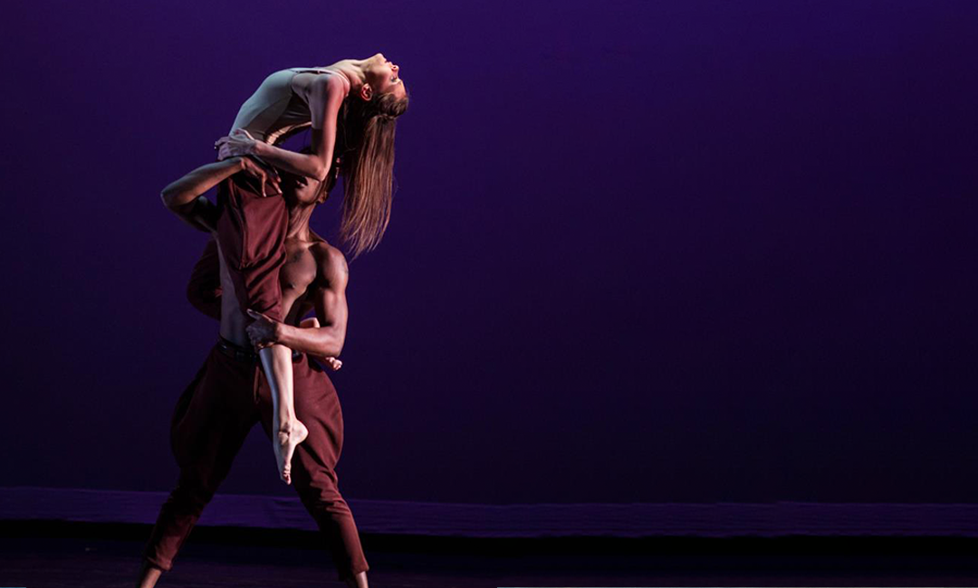 A male holding up a female partner during a dance performance