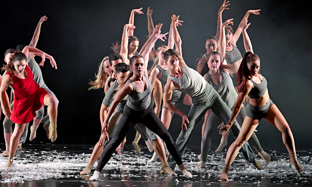 A large group of Jacksonville university dancers on stage with high energy