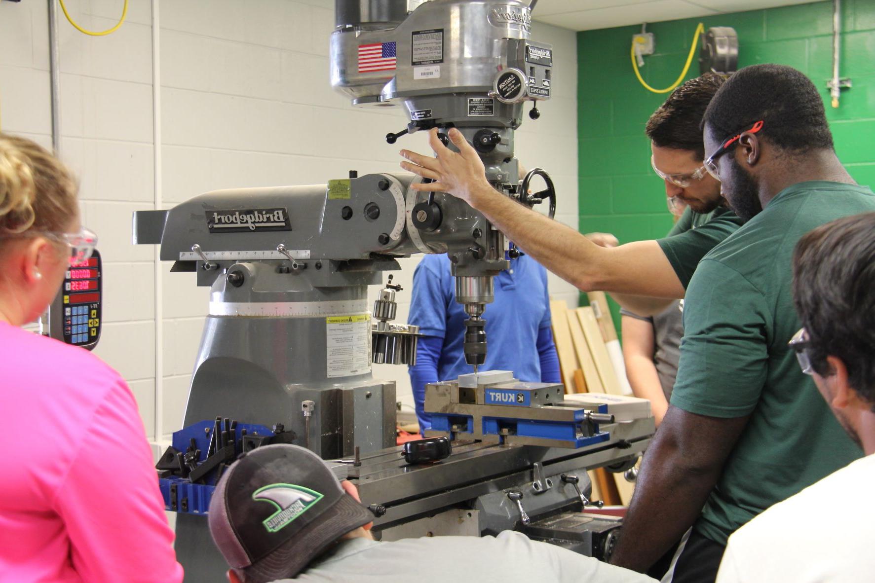 Multiple students working at a machine