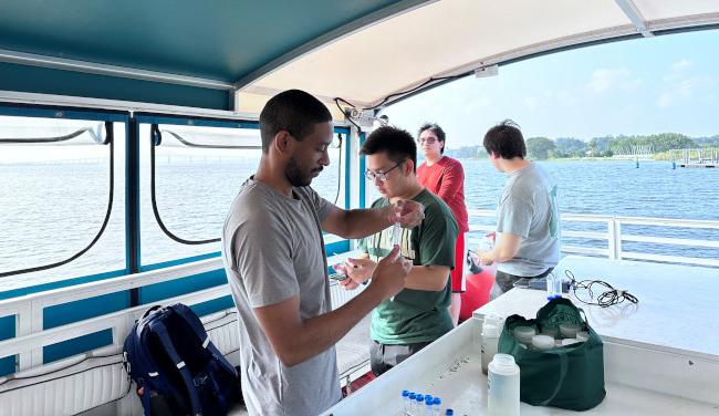 a group of marine biology students on a boat doing research at sea