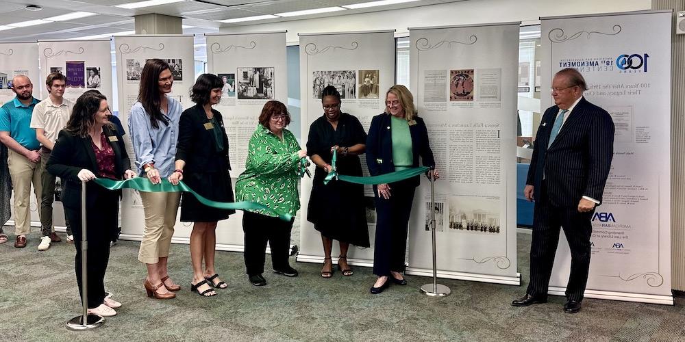 the ribbon is cut for the 19th amendment exhibit in the Swisher Library