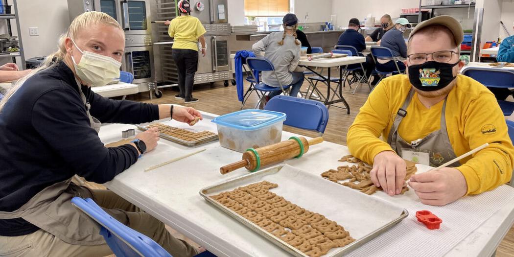 Students sitting at a table, making dog biscuits