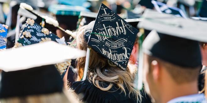 Focused photo on a grad cap on the head of a female JU student that reads 