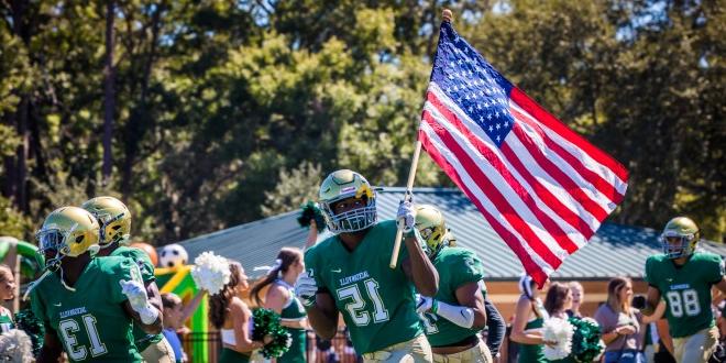 JU football player running with the American flag. 