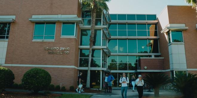 Front view of Davis College of Business building during the early morning hours with students walking out the front doors