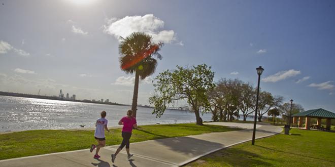 Two runners on JU's Cost Trail by the river.