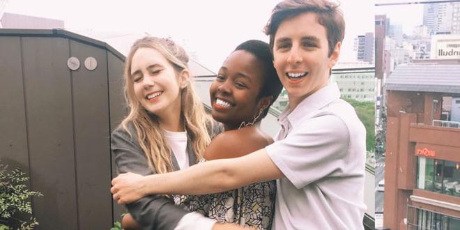 Three JU students in Japan smiling and hugging on a balcony