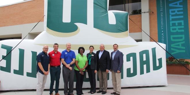 group poses in front of JU inflatable