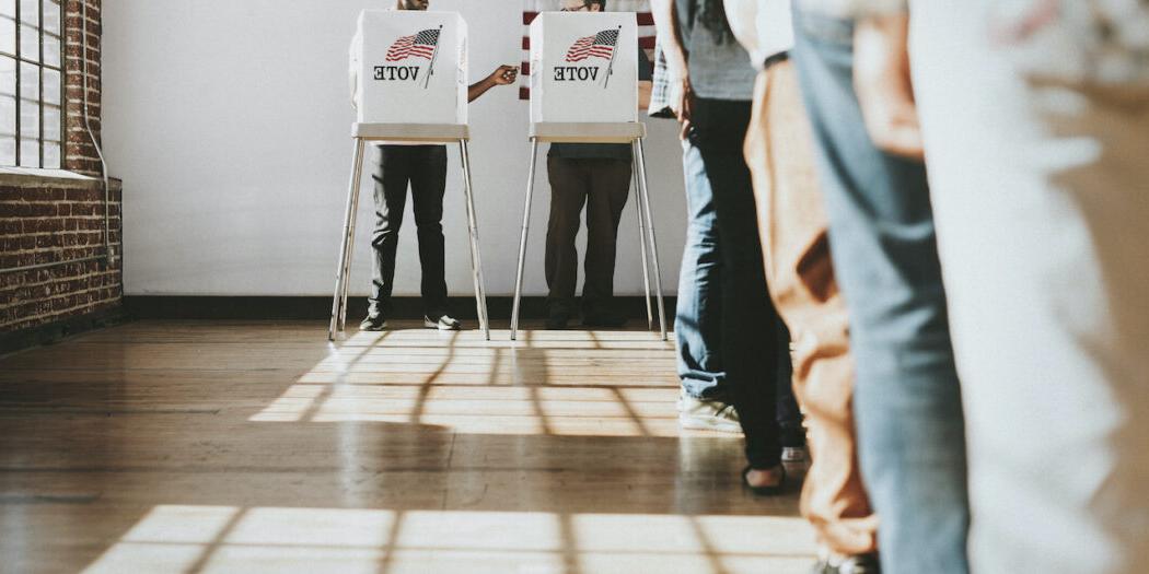 Stock image of people waiting in line to vote