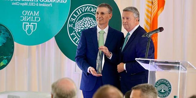 Mayo Clinic President & CEO Gianrico Farrugia, MD, holds the Presidential Global Citizen Award and poses for pictures with President Tim Cost